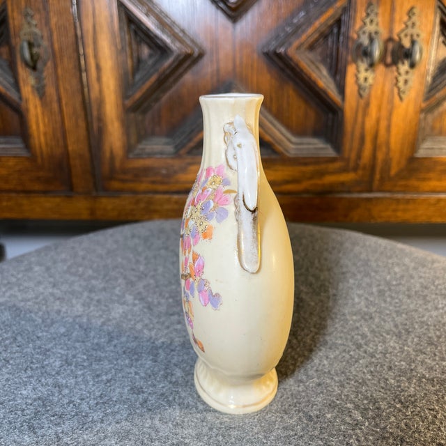 Beautiful shape and form with branch and floral motif. Almond background with pastels of pink, violet, and orange with...