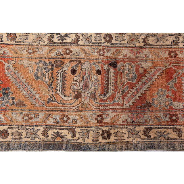 An early 20th century Persian Malayer antique rug, the abrashed brown and blue field with a spacious trellis of palmettes...