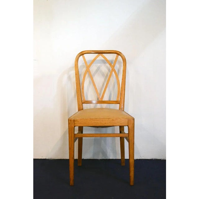 This set of six chairs, with structures in very light ash, feature original seats covered in vipla with studs. They retain...