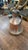 An authentic antique handcrafted copper pitcher featuring a heavily textured hand-hammered finish with aged patina and...