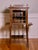 A unique music or display cabinet in walnut with an easel stand and beveled glass door, circa 1910s. A beautifully shaped...