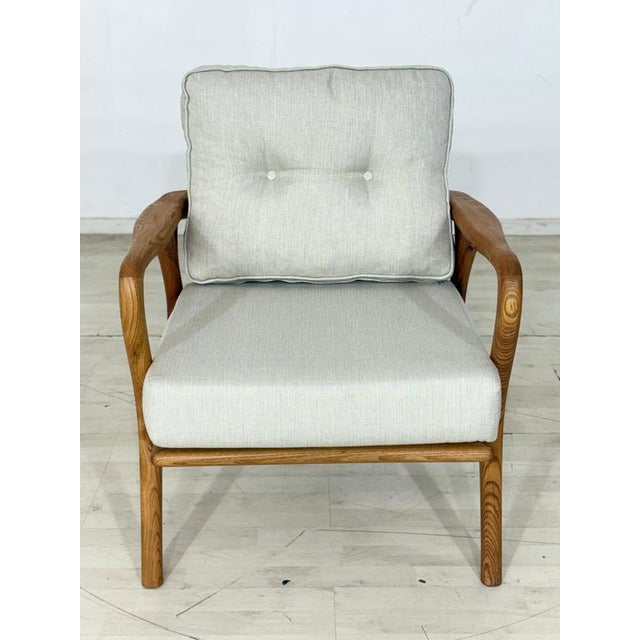 Armchair in a modern retro design with a solid frame made of fine chestnut wood and light, comfortable upholstered...