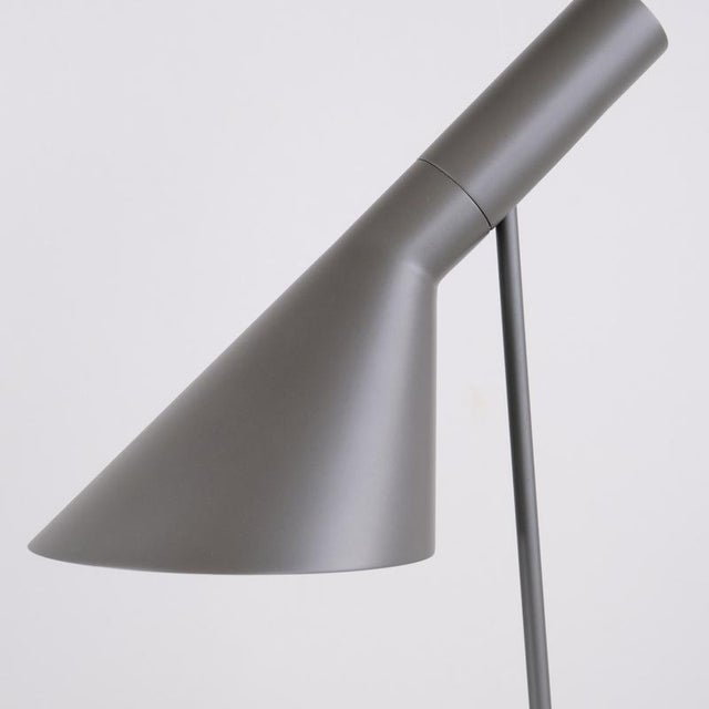 Aj table lamp designed by arne jacobsen in 1957 for louis poulsen. The lamp is made in grey lacquered metal with a...