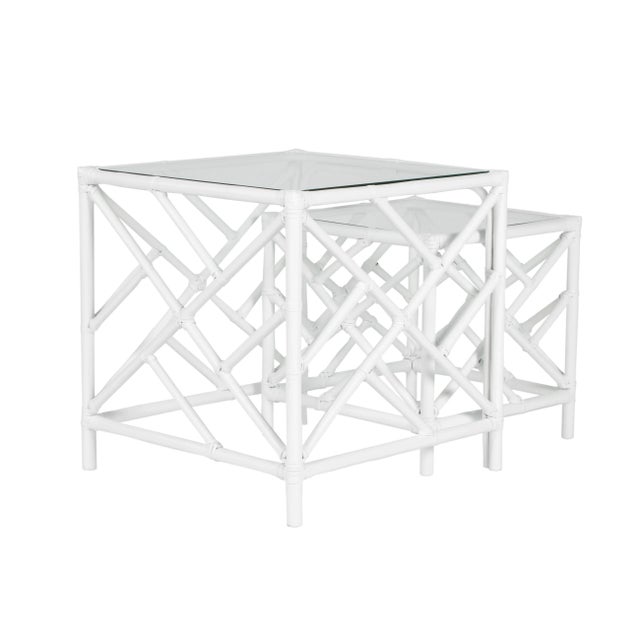 In a classic chinoiserie style, this set of two rattan nesting tables feature a rattan frame, rawhide bindings, hand...