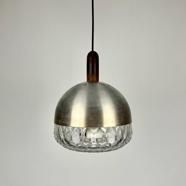 Mid-Century Modern Italian Pressed Glass Pendant Lamp in Brushed Metal and Wood from Stilux Milano, 1960s This piece is...