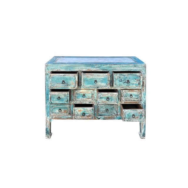 This is a striking antique-style cabinet, radiating rustic charm with its distressed turquoise blue finish. The cabinet...