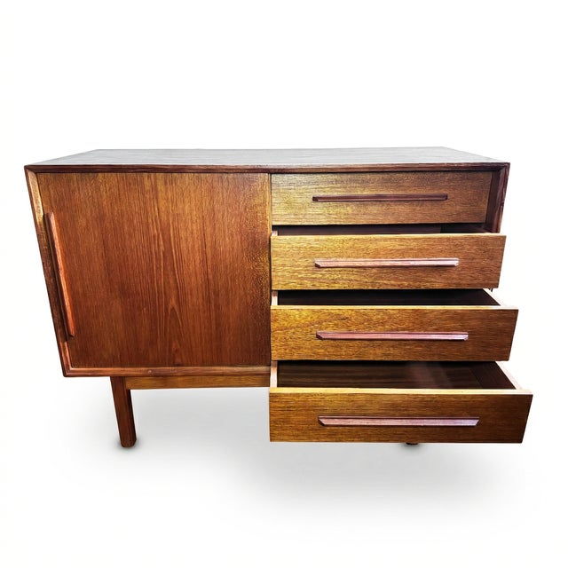 Compact and well-proportioned, this Scandinavian modern teak credenza combines a single sliding door cabinet with four...