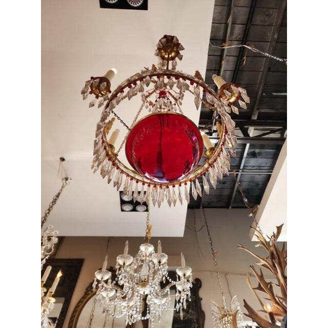This listing features an Empire style Gilt-brass and cut-glass chandelier that houses five candlestick lights and is...