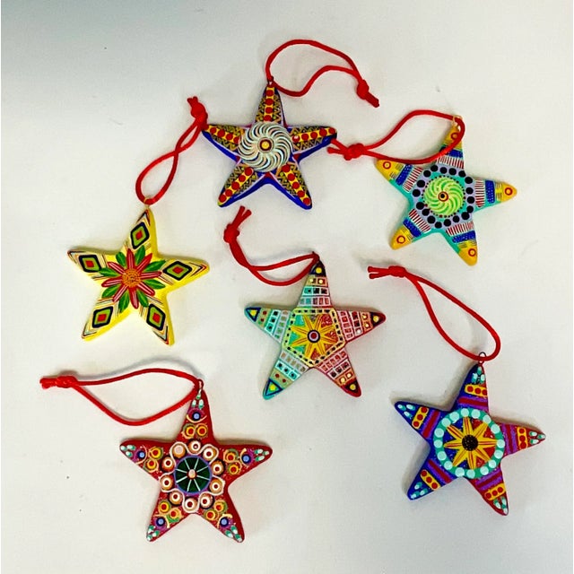 This is a set of 6 hand-painted Christmas Ornaments from Mexico. They are a ceramic clay composition with silk red cords...