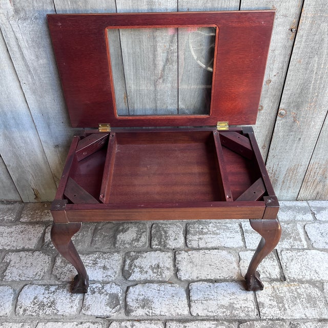 A wonderful antique mahogany bijouterie (display) table in the Chippendale manner, featuring a hinged glass-topped lid...