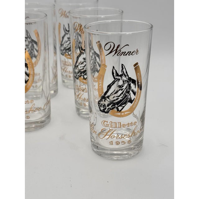 A striking set of eight vintage barware glasses celebrating classic equestrian style. Each glass features a bold black...