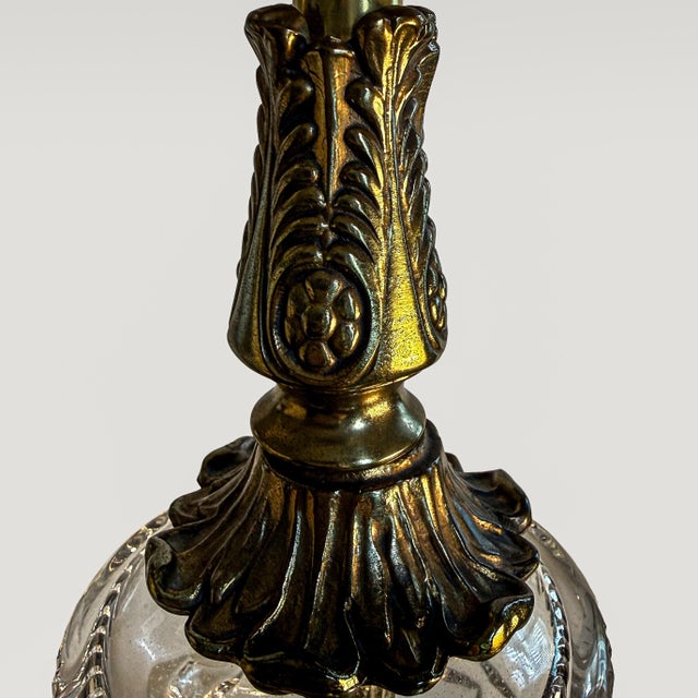 A striking pair of vintage neoclassical table lamps featuring finely cut crystal bodies paired with warm brass detailing....