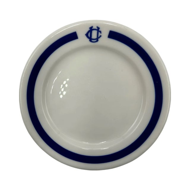 Details: -Plate is white ceramic with blue stripe around edge and features iconic University Club logo in blue. -Approx....