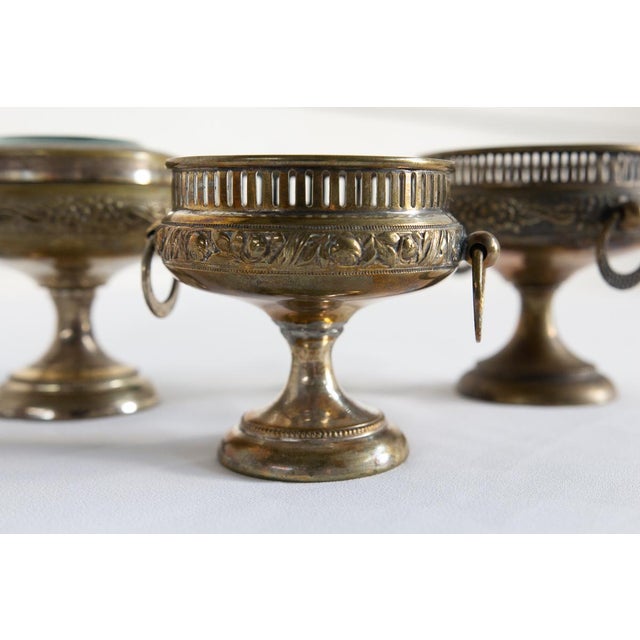 The three brass risers are coordinated to hold small jewelry and objects and were kept on toilets. One features glass and...