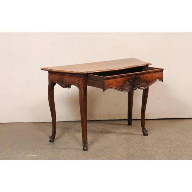 An elegant French carved wood console table, with single drawer, from the turn of the 18th and 19th century. This antique...