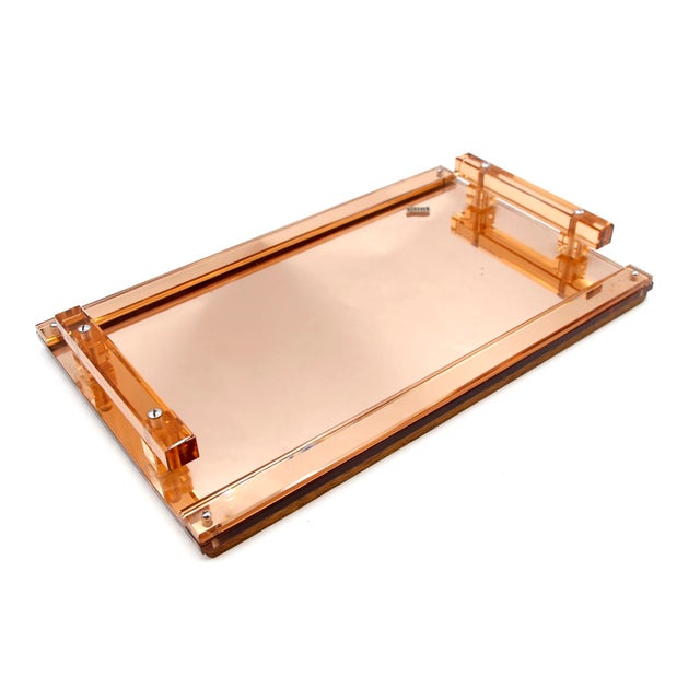 European 1950s light orange translucent lucite mirrored tray, with two lucite handles and two strips of wood attached to...