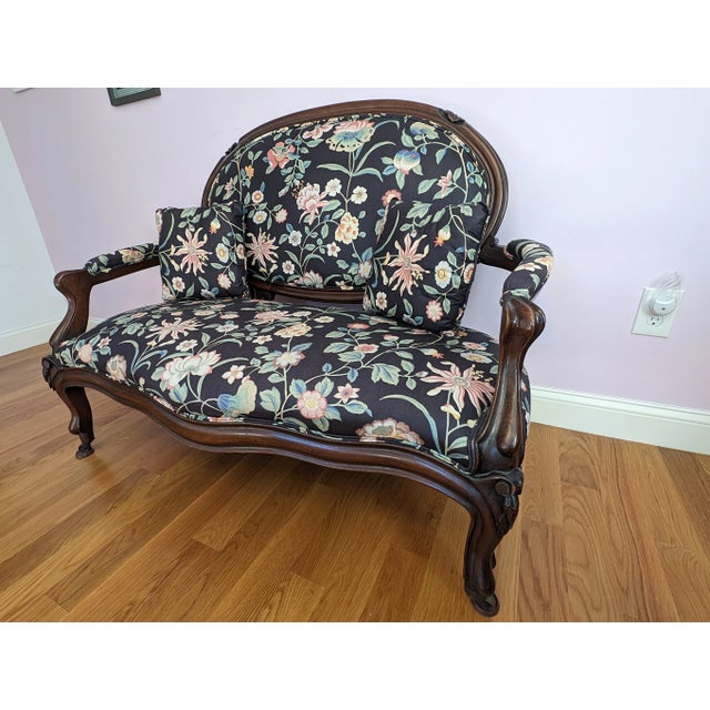 An elegant and charming small Louis XVI-Style settee, covered in vibrant blue silk with printed peonies and other flowers....