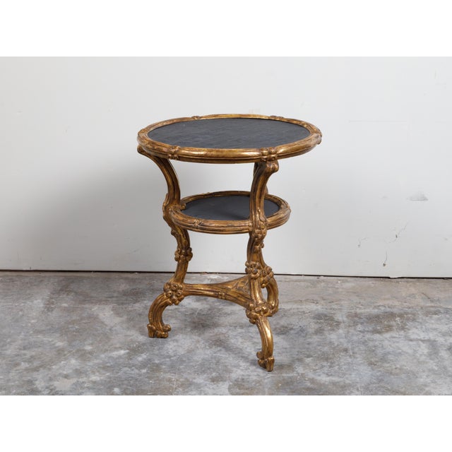 An Italian giltwood side table from the early 20th century, with slate top, shelf and cabriole legs. Created in Italy...