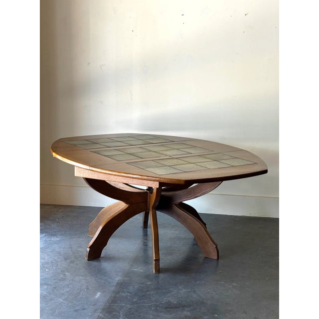 Solid oak dining table with six sculptural leg and a curved octagonal top. Features a speckled sage tile top with floral...