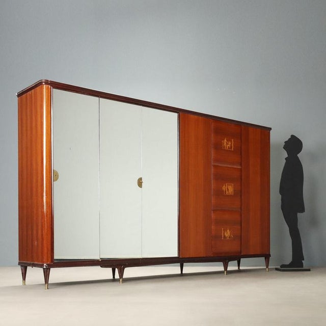Large Italian-made wardrobe from the 1950s featuring elegant exotic wood veneer, providing a warm and sophisticated...