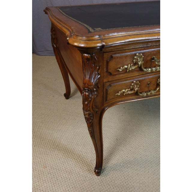 Large walnut desk with pull-out slides and five drawers in the front. This desk was made by the potheau constantin firm in...