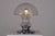 Table lamp consisting of a blown glass dome studded with inclusions, set in a circular chrome-plated steel base. 1970s...
