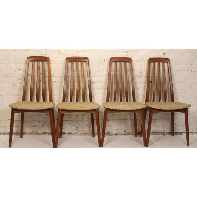 This is set of four teak and tweed dining chairs. The chairs are a classic slat back design allowing them to be both...