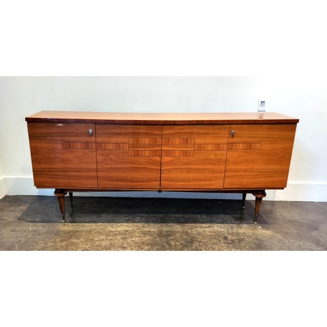 Mid Century Modern French sideboard in rich walnut wood with minimalist veneer design at center. Four doors open to reveal...