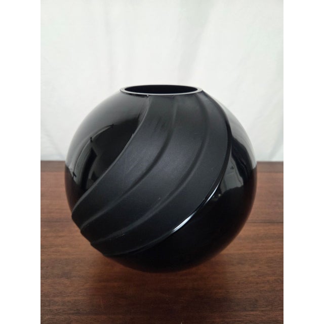 This striking black amethyst glass vessel brings depth, weight, and quiet drama to an interior. Its rounded, sculptural...