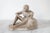 1950's seat nude figural male clay sculpture. No makers mark. One older repair, small nicks. Pictured.
