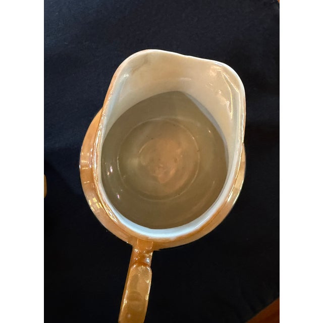 This charming vintage sugar bowl and creamer set features a luminous iridescent blue glaze accented with warm gold luster...