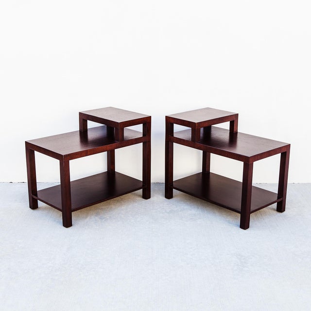 Expertly refinished two-tier dark mahogany step tables by T.H. Robsjohn Gibbings, produced by the Widdicomb Furniture...
