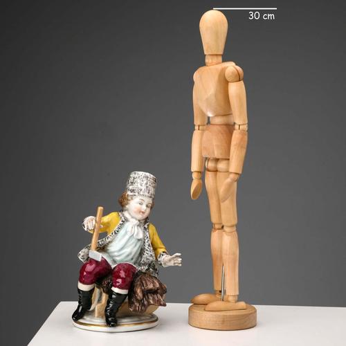 German polychrome porcelain figurine depicting a child wearing a fur hat. Possibly an allegorical depiction of winter....