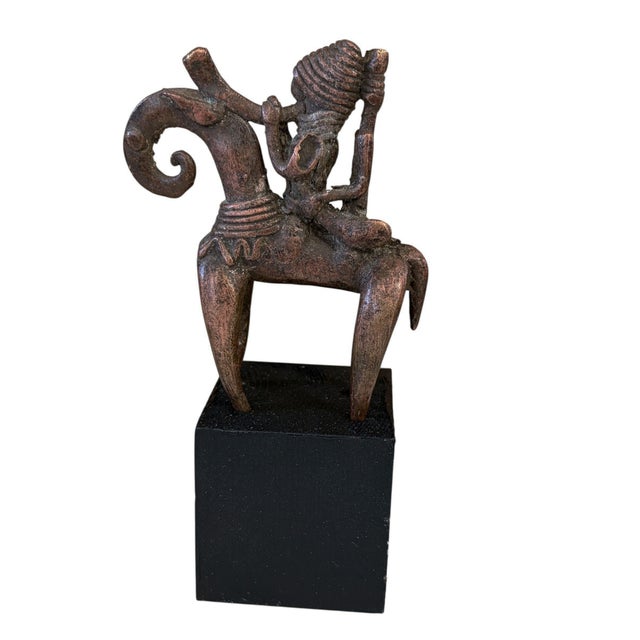 This vintage Dogon bronze equestrian figure on a black wooden stand is a mrammuo—a traditional gold weight—measuring 5.75"...