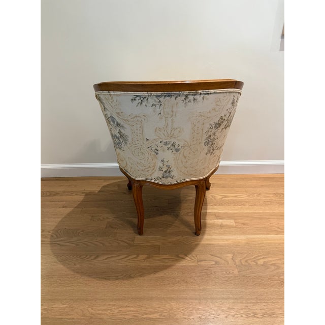 Elegant antique French Louis XV Bergere chair featuring a beautifully carved solid wood frame with graceful cabriole legs,...