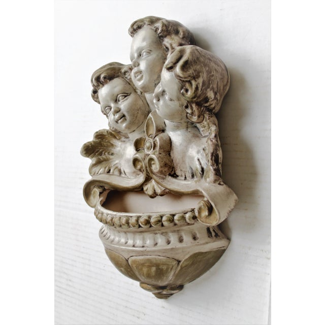 Exceptional antique Italian winged cherub trio wall pocket. The pocket is hand-painted with soft gilt details and raised...
