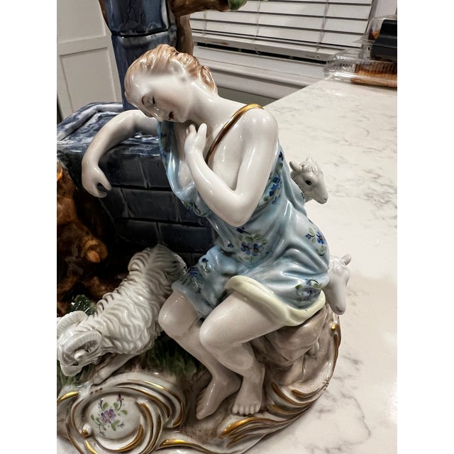 An exquisite multi-figured porcelain figurine of a Shepherd, Shepherdess, and their dogs and sheep. Beautifully hand-...