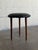This round tripod footstool features a minimalist silhouette and three tapered legs. The compact design allows for...