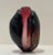 Striking hand-blown studio art glass vase featuring layered ruby, amber, and smoke hues in a fluid, sculptural form. The...