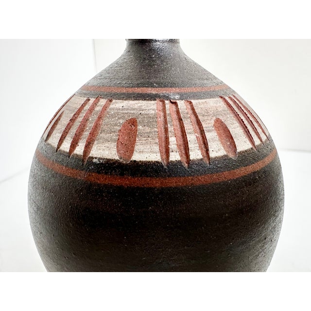 Hand-thrown studio ceramic vase with an egg-shaped body and narrow neck, dating from the 1960s. The red clay body is...