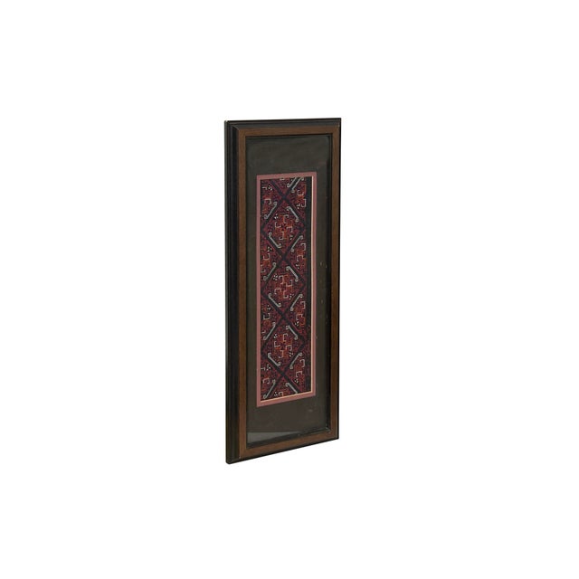This framed vintage textile features an intricate display of traditional ethnic embroidery, likely a sleeve band or...