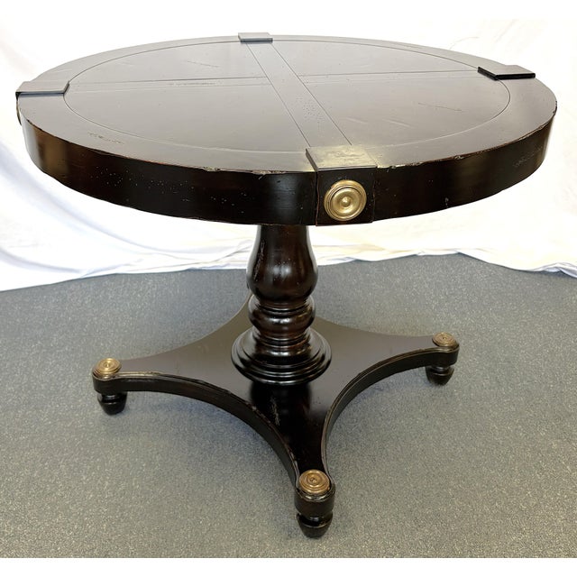 Timeless vintage pedestal table from the late 20th century. The neoclassical style table is made of heavy wood in a deep...