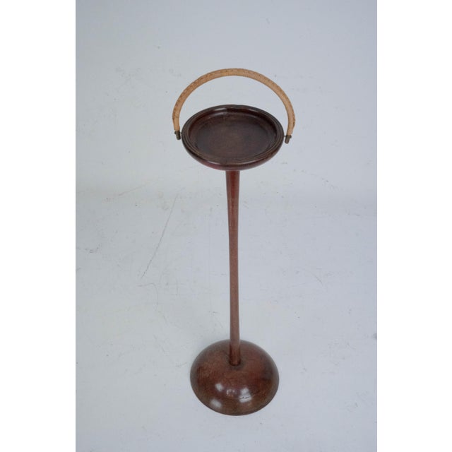 Elegant vintage ashtray stand crafted from solid wood, featuring a turned pedestal base and a circular tray top. The...