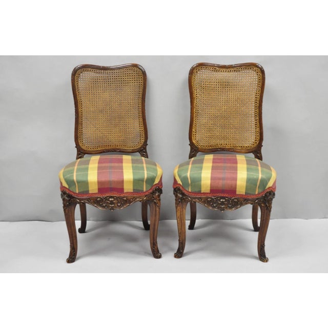 Antique French Country Louis XV Style Carved Frame Walnut Cane Back Side Chairs with Plaid Printed Upholstered Seats - a...