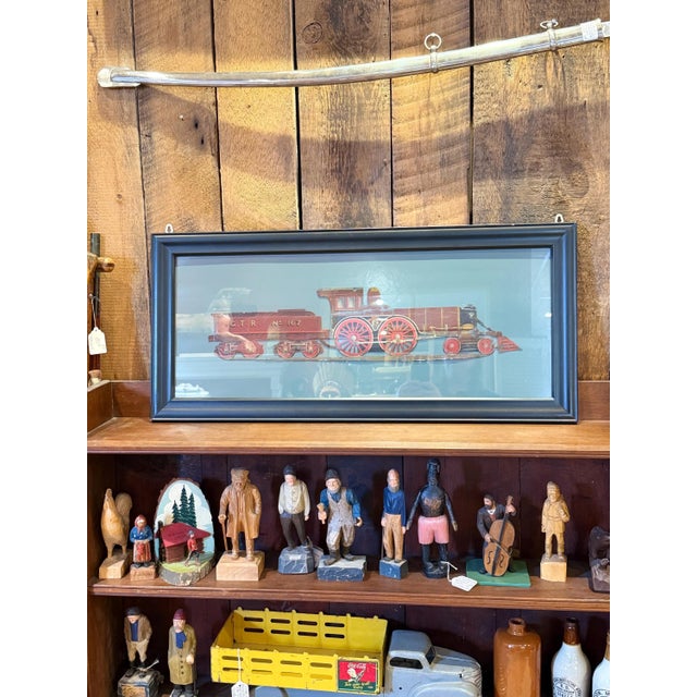 Striking antique Grand Trunk Railway metal sign featuring a detailed depiction of a steam locomotive and coal tender,...