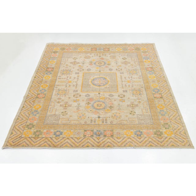 Enhance your space with this Modern Khotan Style wool rug, featuring a sophisticated blend of sand, goldenrod, slate blue,...