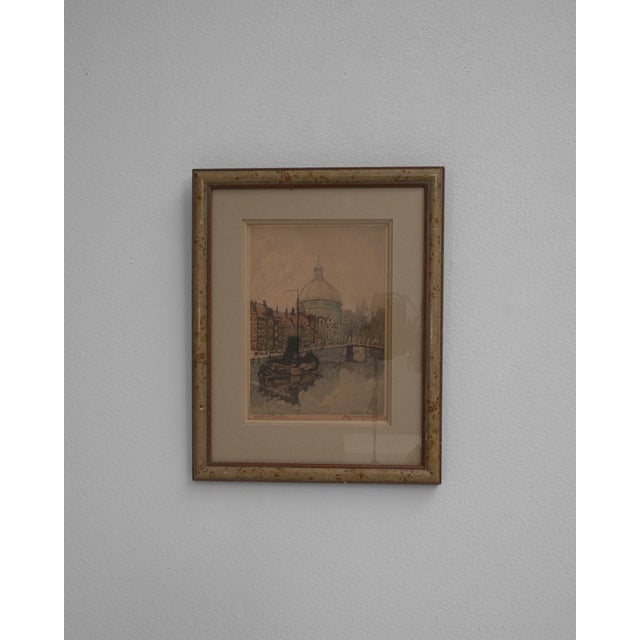 This 20th Century Belgian wall art with wooden frame presents a delicate architectural scene rendered in soft, muted...