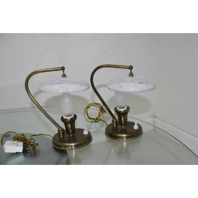 This set of two perforated brass table lamps was designed during the 1950s, and manufactured in Italy. Each lamp features...