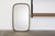 An elegant wall mirror from the 1950s, featuring the timeless aesthetic of post-war modernism. Its form is based on a...