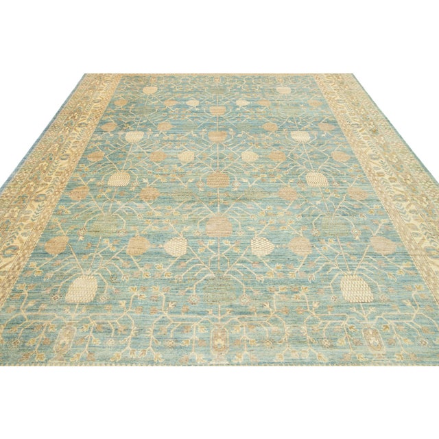 This exquisite modern Khotan-style hand-knotted wool rug features a light blue field. The piece is elegantly framed with...